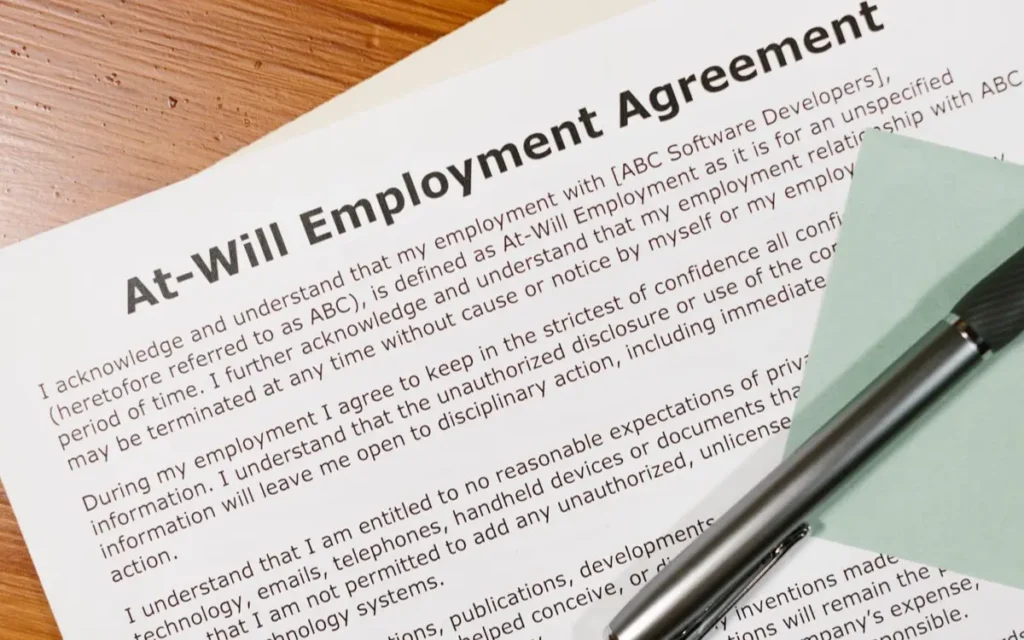 Close-up of an at-will employment agreement on a wooden desk